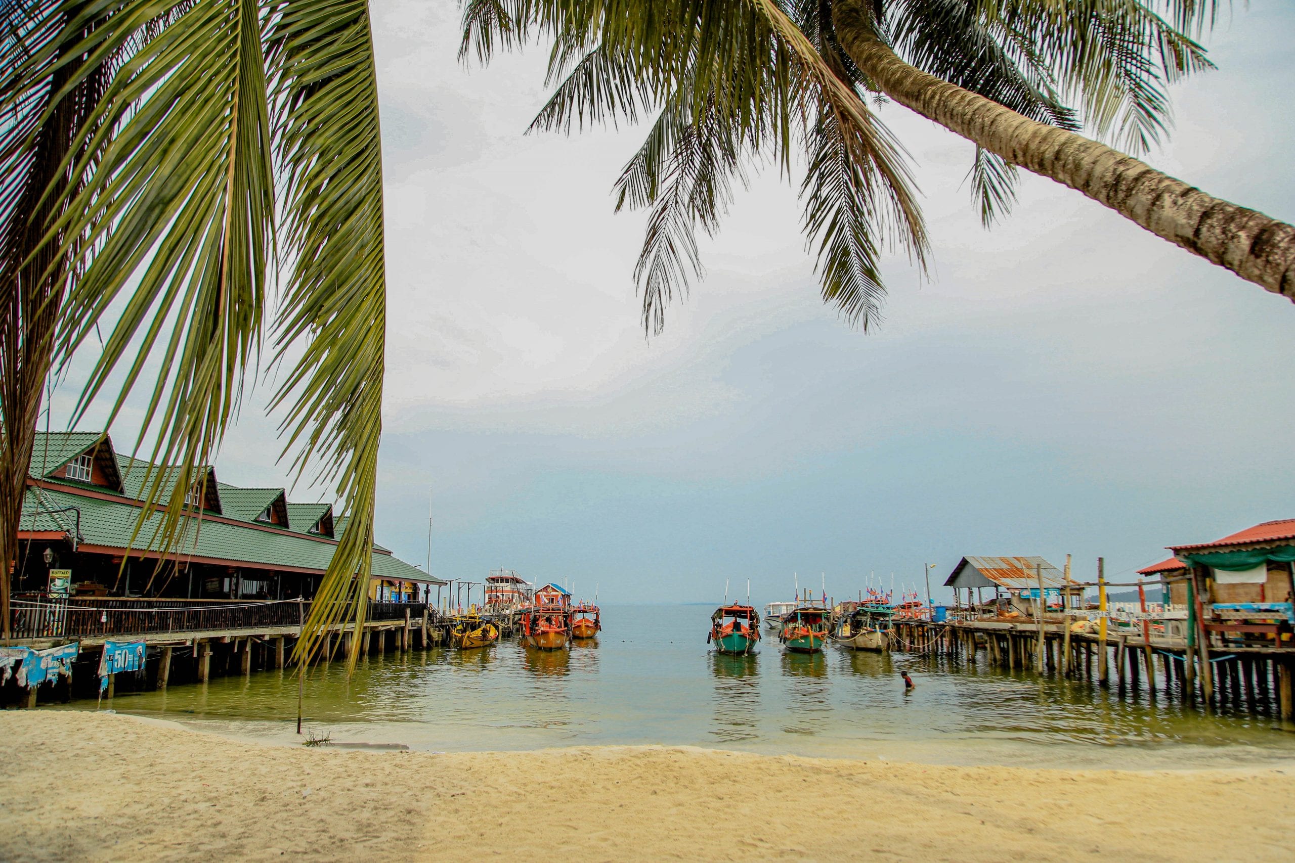 Koh Rong Beach, palm trees and boat on the ocean on Koh Rong, Cambodia