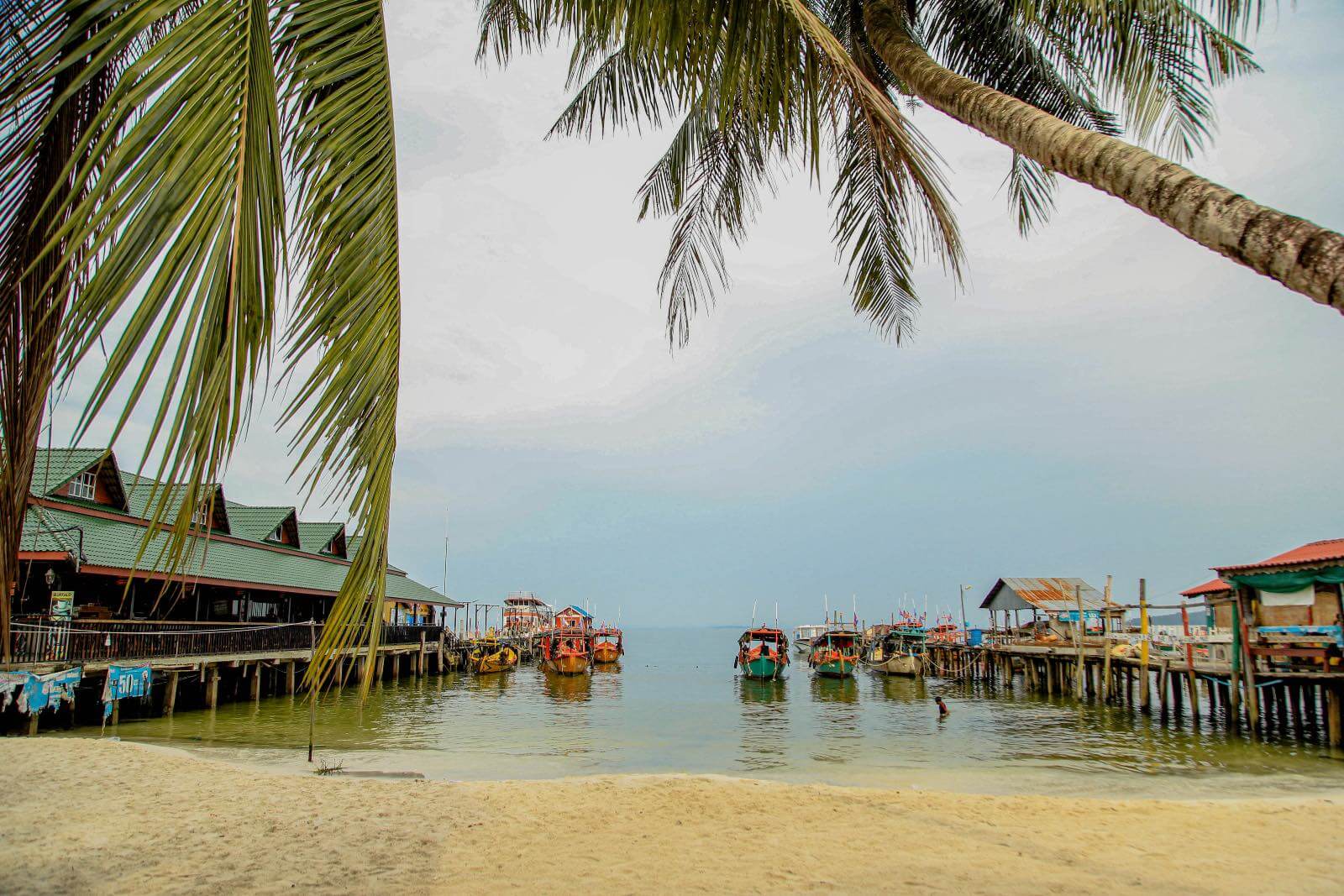 Picture perfect Koh Rong, Cambodia Palm tree on a beach looking into a boat harbor in Koh Rong, Cambodia