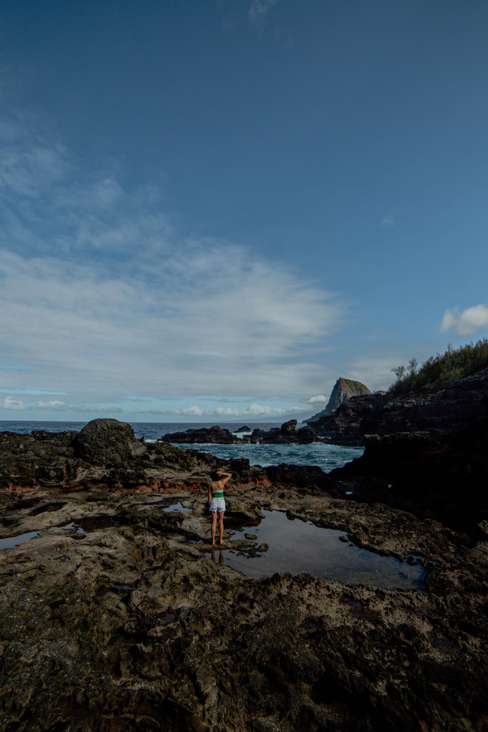 Olivine Pools Things to do on Maui Girl standing on rocks near the ocean at Olivine Pools