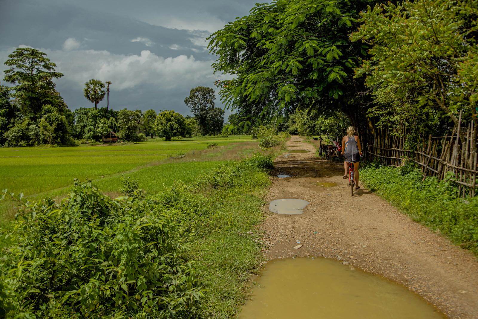 I'm Jess Traveling riding down a dirt road in Don Det, Laos Riding bicycles in Don Det, Laos