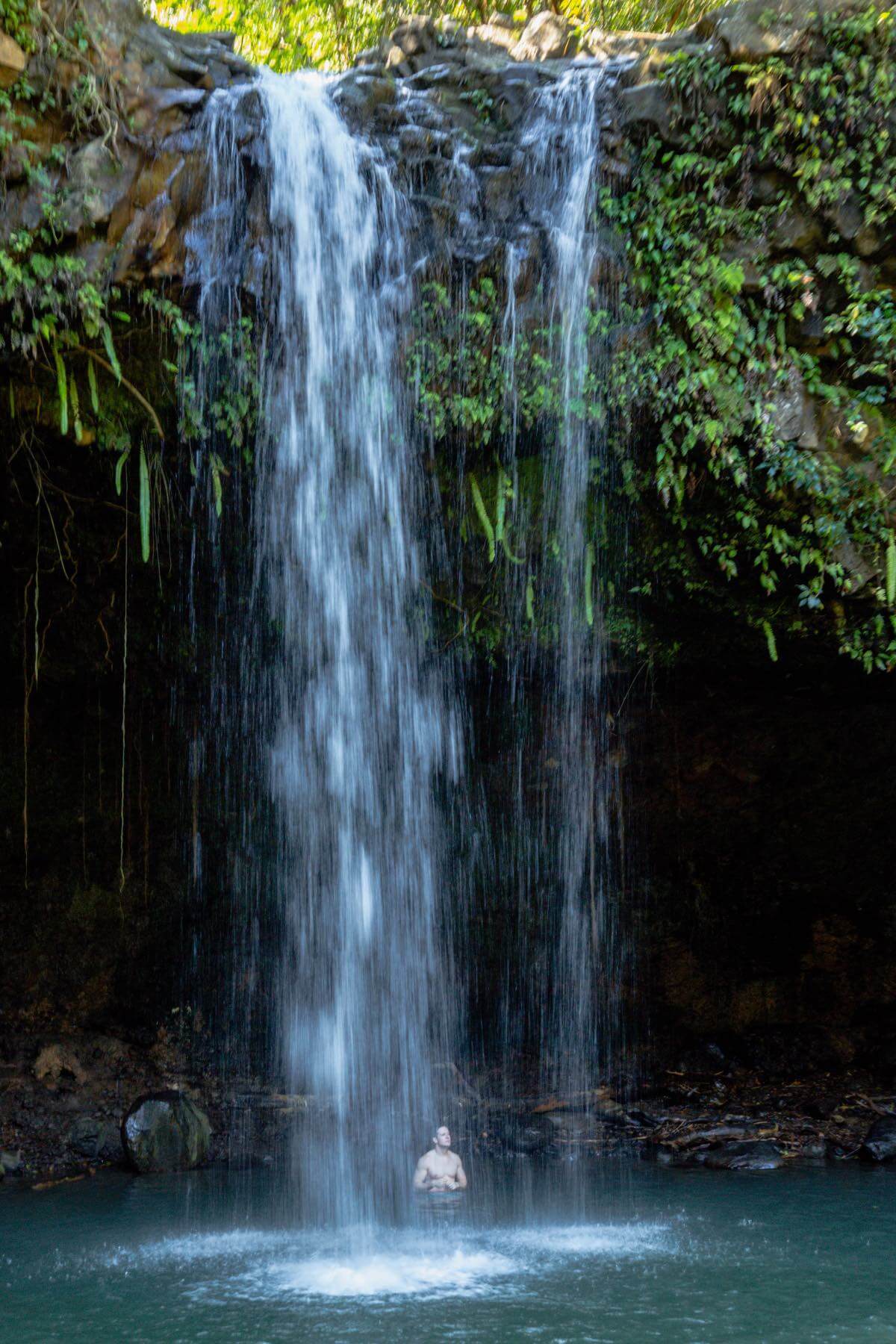 Guy under a waterfall at Twin Falls on Maui