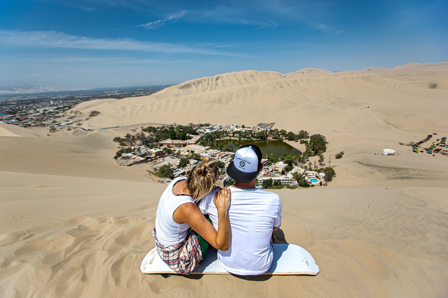 Jess & Joe sitting on the Huacachina sand dunes above the Peru Oasis